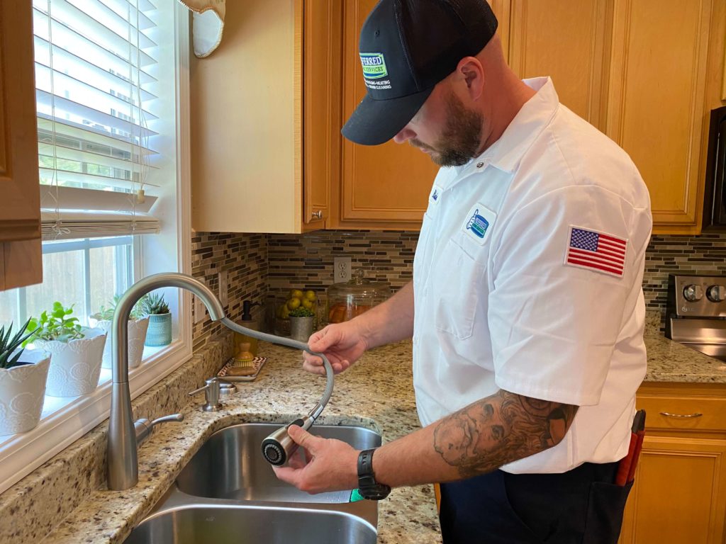 plumber examines kitchen faucet