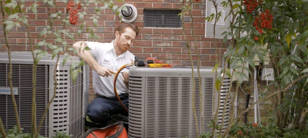 Preferred Home Services employee working on an outdoor AC compressor