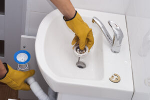 Plumber cleaning out a bathroom drain