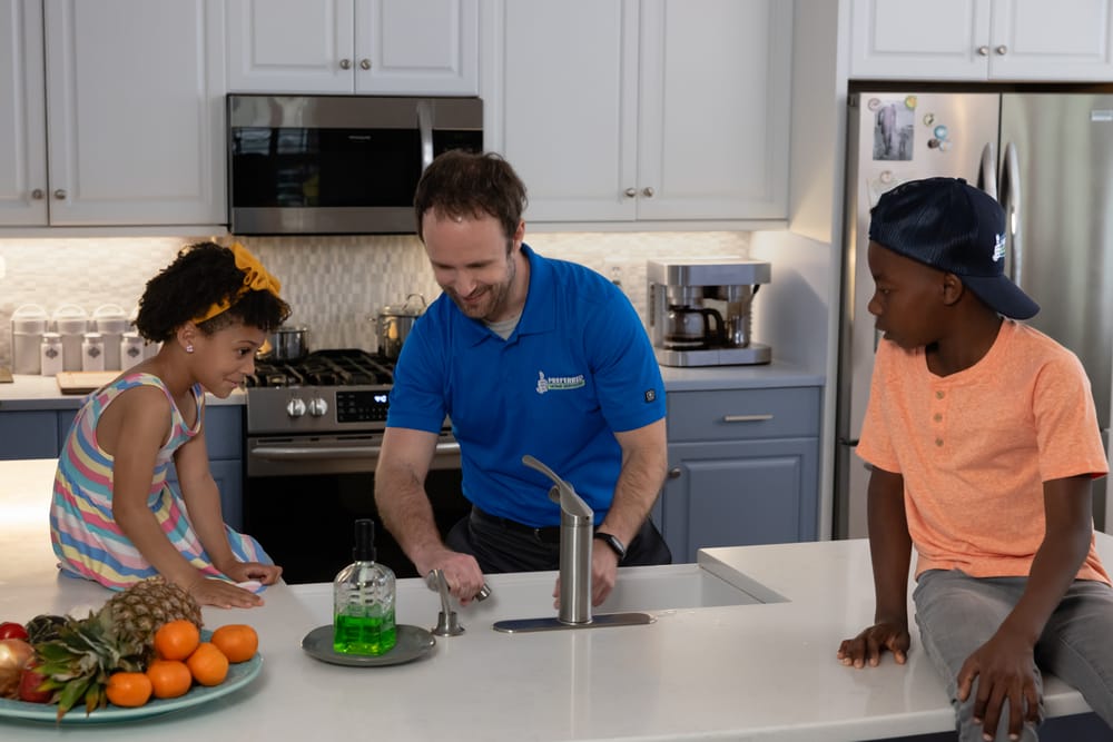 A Preferred Home Services technician shows a smiling family that their water is flowing again as a result of a professional frozen pipe repair in the South Carolina.