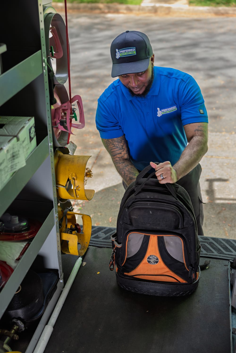 An expert Preferred Home Services electrician collects his tool bag from a branded service van to prepare for a professional electrical panel replacement.