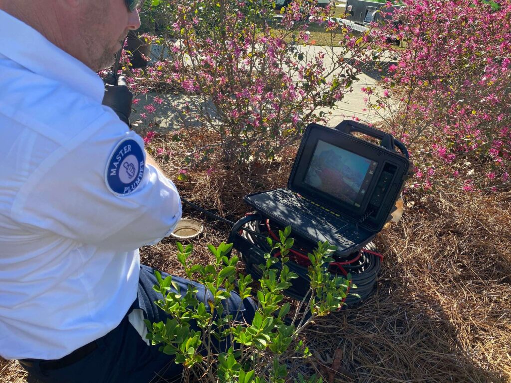 A Preferred Home Services master plumber uses a high-resolution sewer camera to identify a mainline pipe blockage in a South Carolina yard.